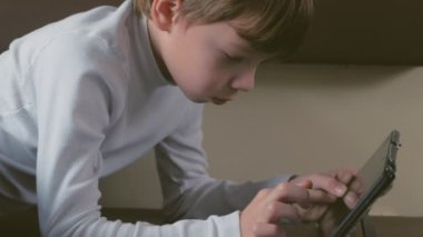 Çocuk trende bir tablet alt rafta döşeme ikinci sınıf bir satır boşluğu içinde oynuyor.