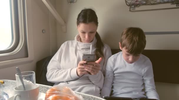 Mãe e filho em gadgets viajando de trem está jogando um jogo em uma carruagem de segunda classe . — Vídeo de Stock