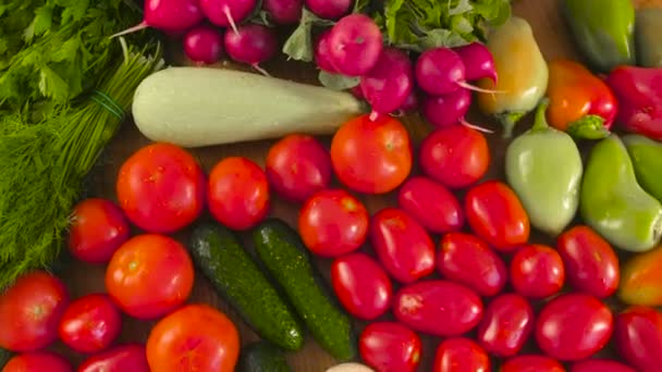 Свіжі овочі помідори, огірки, кабачки, перець, зелень, редька та гриби на кухонному столі. Крупним планом перегляд . — стокове відео