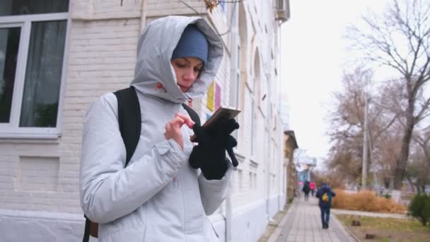 Женщина заблудилась в городе и ищет маршрут с помощью навигатора в мобильном телефоне . — стоковое видео