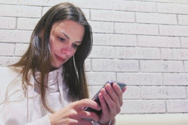Kadın oturuyor ve biri kafede bekliyorum cep telefonunda bir mesaj yazarak