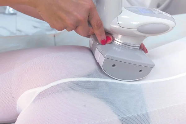 Kosmetolog gör en kvinna i nylon passar lpg massage booty, ben, kropp. — Stockfoto
