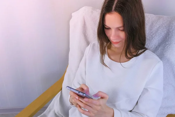 Joven morena leyendo un mensaje en un teléfono móvil . — Foto de Stock