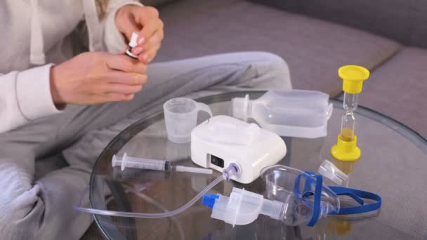 Femme met la médecine dans la partie de l'inhalateur. Les mains en gros plan. Médicament pour inhalation et nébuliseur sur la table en verre . — Video