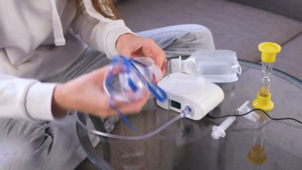 Kvinnan samlar en inhalator för behandling, fyller den med medicin. — Stockvideo