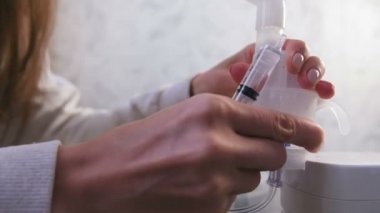 Kadın inhaler kapsayıcısı içine şırıngadan tuz dökülen.