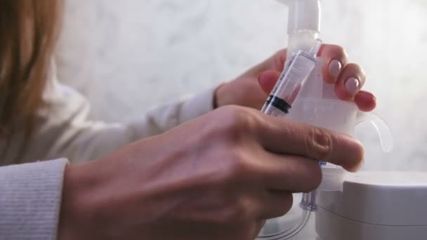 女性は、吸入器のコンテナーに注射器から生理食塩水を注ぐ. — ストック動画