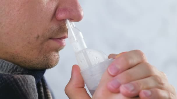 Hombre enfermo inhalando a través de la boquilla del inhalador para la nariz. Nariz de cerca, vista lateral. Utilice nebulizador e inhalador para el tratamiento . — Vídeo de stock