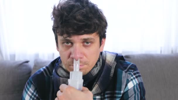 Больной человек вдыхает через сопло ингалятора для носа. Крупный план, вид спереди. Использование ингалятора и распылителя для лечения . — стоковое видео