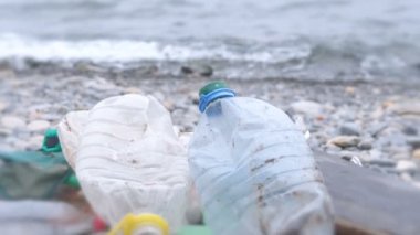 Taş sahilde kirli plastik şişe. Çevre kirliliği.