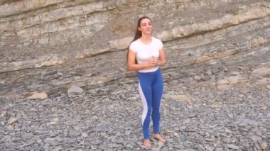 Kız egzersiz hamle yapıyor, bacak kaldırma bodyflex sırasında nefes egzersizleri kaya zemin üzerine.