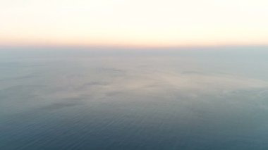 Güzel kadın yoga stretcing ve gün batımında deniz manzaralı dağ üstüne meditasyon yapıyor. Havadan görüntüleri. Arkadan görünüm.