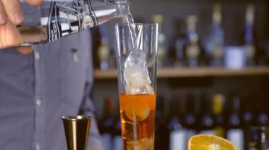 Barmen maden suyu dökülen ve köpüklü şarap şampanya flüt alkol kokteyl hazırlar. Eller yakın çekim.