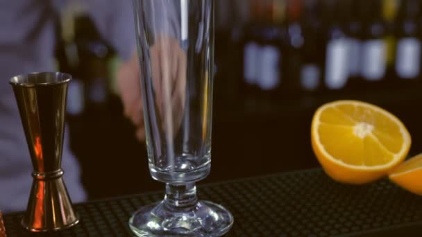 Barman met du glaçon dans la flûte de Champagne pour un cocktail. Gros plan des mains . — Video