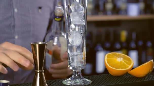 バーマンは シャンパンにジガーから酒を注ぐアルコール カクテルと氷のフルート 手のクローズ アップ — ストック動画