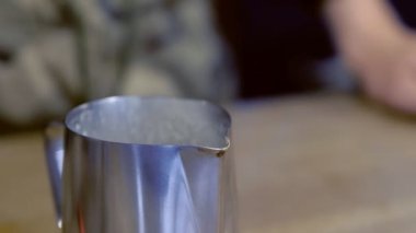 Barista kahve sürahi içinde yapıyor, tuz ve şeker koyar. Eller yakın çekim.