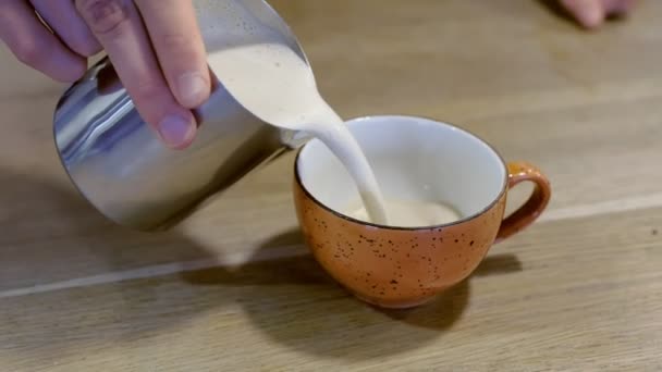 Profi-Barista gießt frischen Kaffee Capuccino von Krug zu Tasse. Hände aus nächster Nähe. — Stockvideo