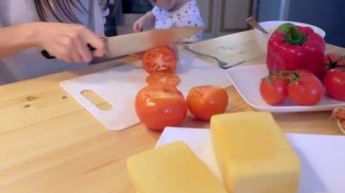 Annem onun çocuklar için akşam yemeği hazırlar, domates keser, yakın çekim eller.