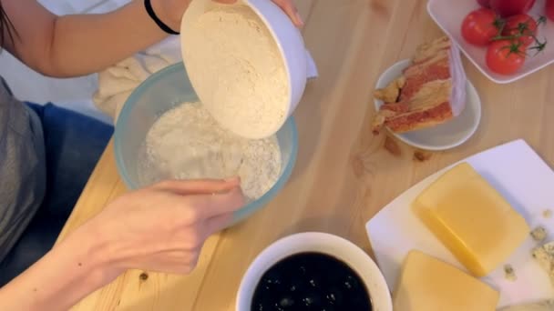 Femme pétrit la pâte à pizza dans un bol. Gros plan des mains . — Video