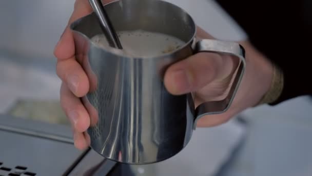 Barista steamig kaffe i kannan med en ånggenerator. Händer närbild. — Stockvideo