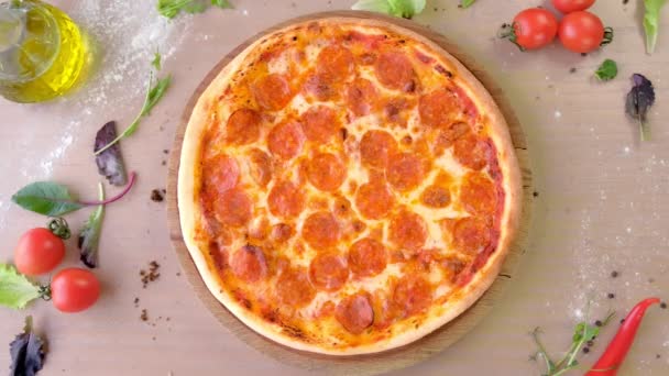 Chef em luvas de borracha leva salame de pizza em uma tábua de madeira da mesa. Mãos à vista . — Vídeo de Stock