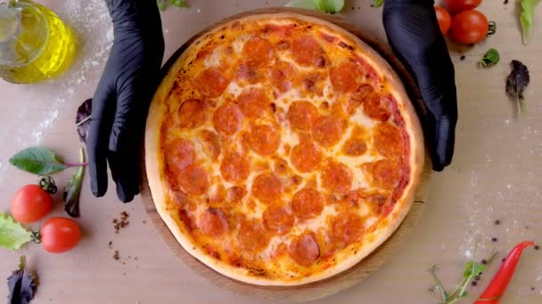 Cook pone hojas de espinaca en las manos de salami pizza en guantes de goma, manos de cerca . — Vídeos de Stock