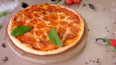 Cook ıspanak yaprakları pizza salam ellerinde lastik eldiven koyar ve pizza dilimleri, yan görünümü keser.