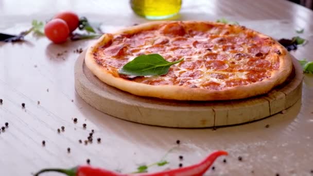 Cook mette foglie di spinaci sulle mani di pizza salame in guanti di gomma, vista laterale pizza primo piano . — Video Stock
