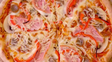 Jambon, mantar ve biber pizza dilimleme. Yakın çekim görünümü.