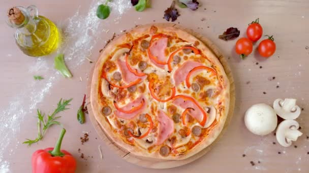 Yemek masada ahşap tahta üzerinde jambon, mantar ve biber rendelenmiş peynir pizza sprinkles. Yakın çekim yakışıklı. — Stok video