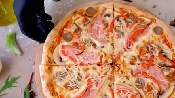Cook neemt een plakje spek, champignons en kaas pizza. Hand in een rubber handschoen close-up. — Stockvideo