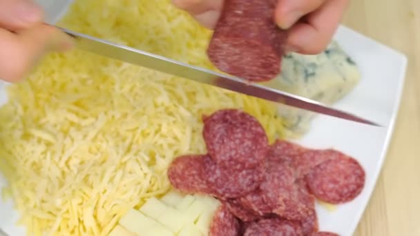 L'homme coupe les mains de saucisses au salami en gros plan. Préparer les ingrédients pour la pizza . — Video