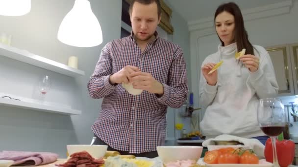 Nuori Perhe Kokkaa Pizzaa Yhdessä Keittiössä — kuvapankkivideo