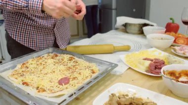 Mutfakta birlikte genç aile aşçı salamlı pizza. eller yakın çekim.