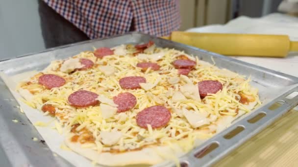 El hombre cocina pizza de salami en la cocina. Primer plano de las manos . — Vídeo de stock
