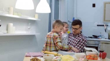 Baba çocukları ile pizza birlikte mutfakta aşçılar.