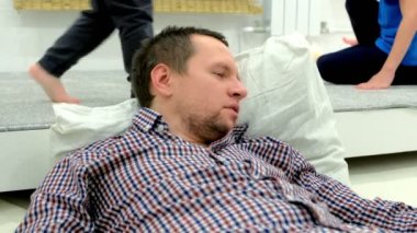 Oturma odasında yorgun uyuyan baba ile çocuk oyun.