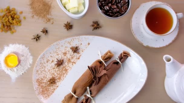 Choklad Ryska pannkakor, blini med curd fyllning på plattan. Serveras med en kopp te och choklad. — Stockvideo