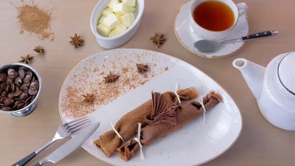 Panqueques rusos de chocolate, blini con relleno de cuajada en el plato. Servido con una taza de té y mantequilla . — Vídeos de Stock