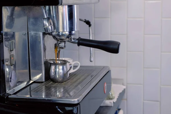 Pouring espresso to pitcher from coffee machine. — Stock Photo, Image