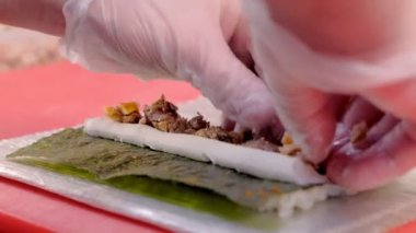 Şef aşçılar balık krem peynir ve nori, verme rulo süreci, yemek tarifi ile alır. Eller yakın çekim.