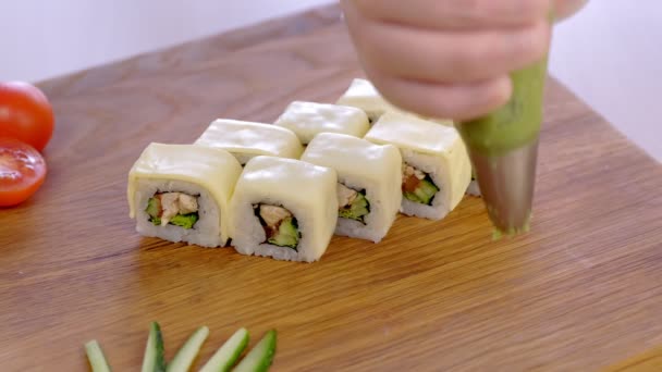 Cuire sert des petits pains avec poulet, concombre, légumes verts et crème sur le plateau en bois avec wasabi et légumes . — Video