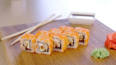 Üst üzerinde balık, karides ve turuncu havyar ile rulo ahşap tahta wasabi ve soya sosu ile servis.