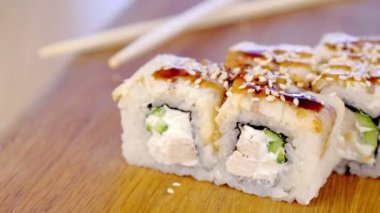 Ahşap pansiyon sause wasabi, zencefil ve soya ile balık ve susam tohumu ile rulo üst hizmet.