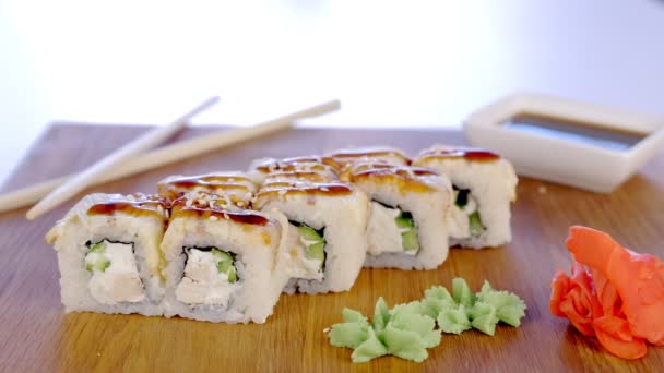 Espolvorear rollos con semilla de sésamo servido en tablero de madera con wasabi, jengibre y soja sause . — Vídeos de Stock