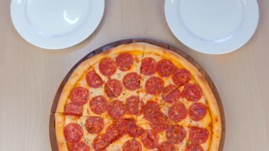 İnsanlar bir dilim salam pizza almak onların plakaları, yakın çekim Üstten Görünüm.