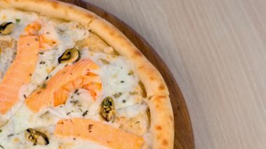 Ahşap masa, yakından görmek deniz ürünleri ve peynir pizza Dilimleme çeyrek.
