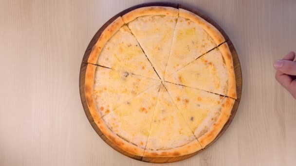 Lidé se plátky pizza Margarita s různými druhy sýrů na dřevěném prkénku detailní pohled shora.