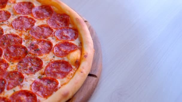 Pizza de salame em tábua de madeira na mesa. Vista de perto . — Vídeo de Stock