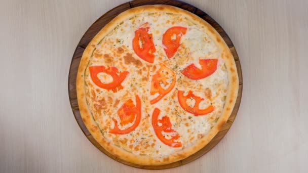 Pizza met tomaten en kaas op houten plank. Bovenaanzicht. — Stockvideo